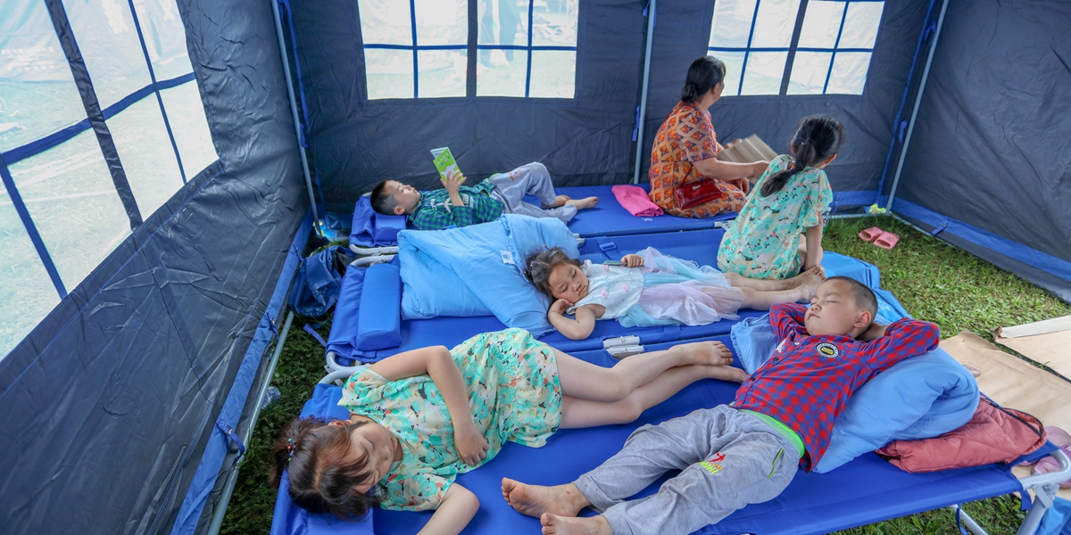 6月18日,在長寧縣雙河鎮雙河中學安置點,受災群眾在帳篷裏休息。(劉昌松攝)